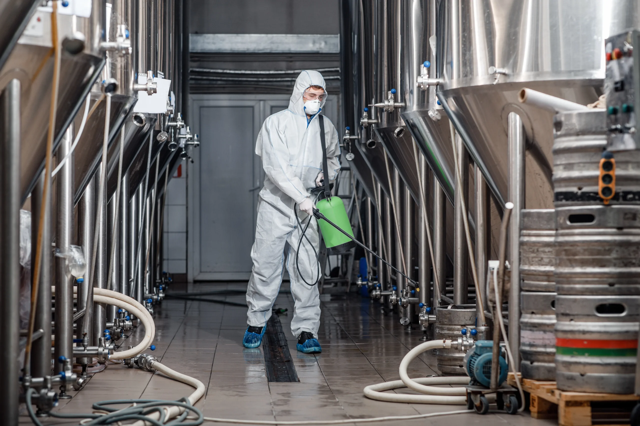 Fotografía de una persona con equipo de protección especial realizando servicio de limpieza industrial.