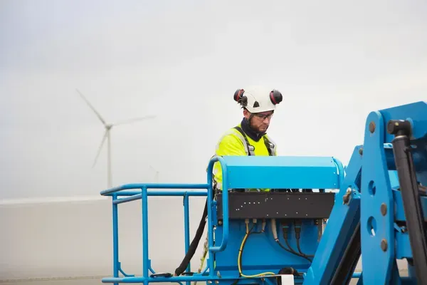 Fotografía de un operador de Genie utilizando un casco blanco y lentes de seguridad mientras realiza su trabajo.