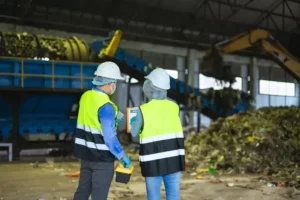Cómo optimizar la recolección de SCRAP dentro de una planta para reducir desperdicios: Dos personas con chaleco y casco.